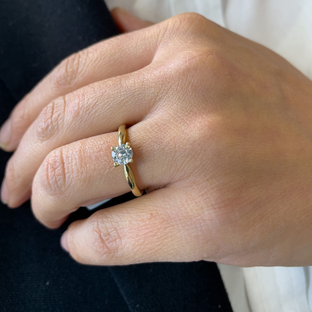 Eine Damenhand mit dem funkelnden Solitär Ring an der Hand in Gelbgold 585/14 Karat Gold